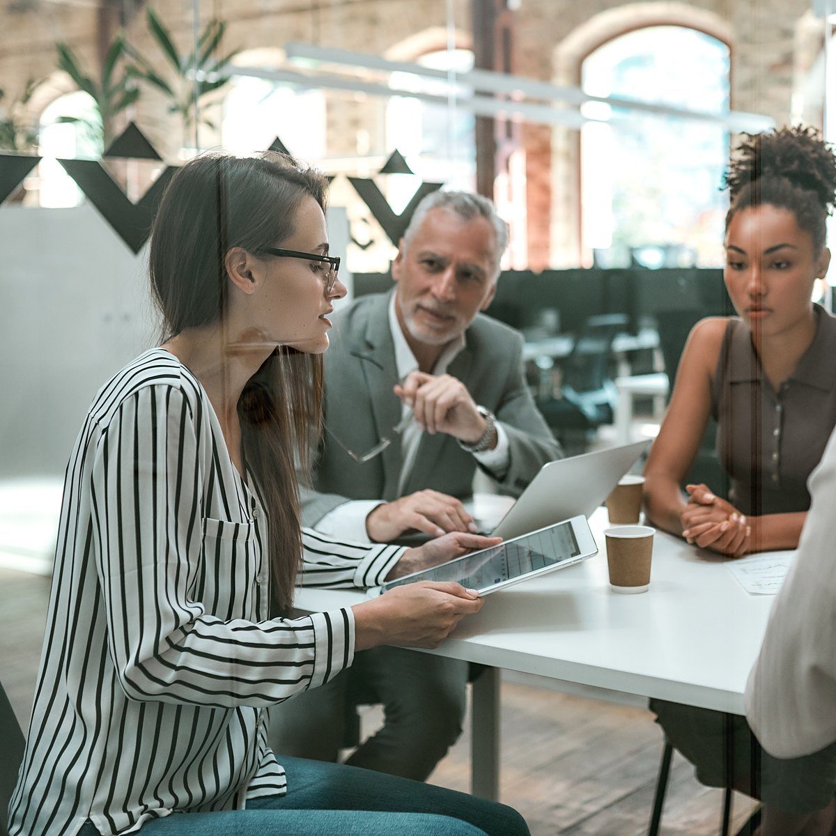 Consultora repasando un plan de crecimiento con dos personas de una startup